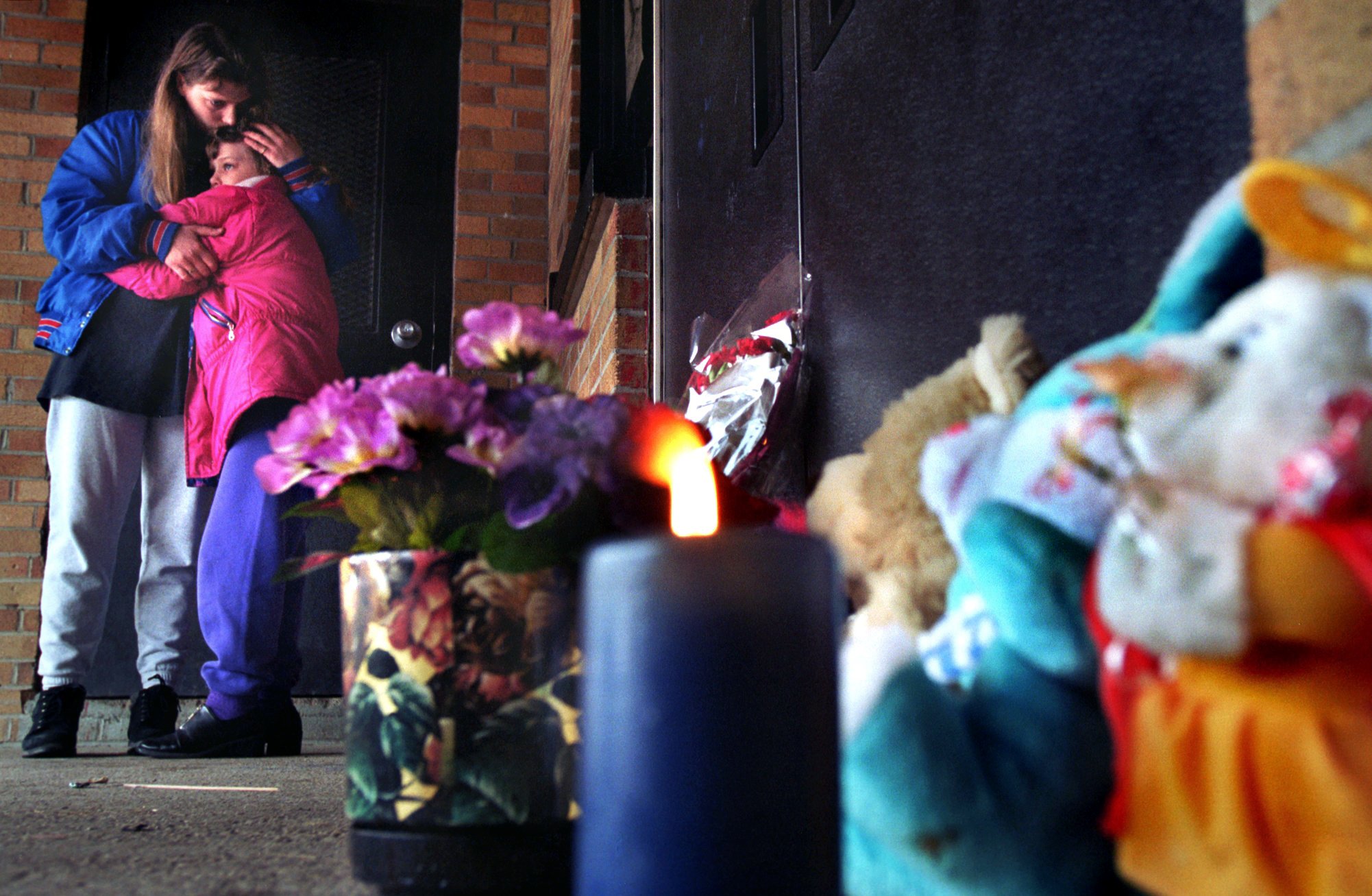Brenda Ide returned to Buell Elementary School with her daughter Maranda, 8, a student at the school to remember shooting victim Kayla Rolland on March 1, 2000. "It's what we needed to do," Brenda told her daughter as they embraced by the memorial at the entrance to the school. (Flint Journal File Photo by Steve Jessmore)
