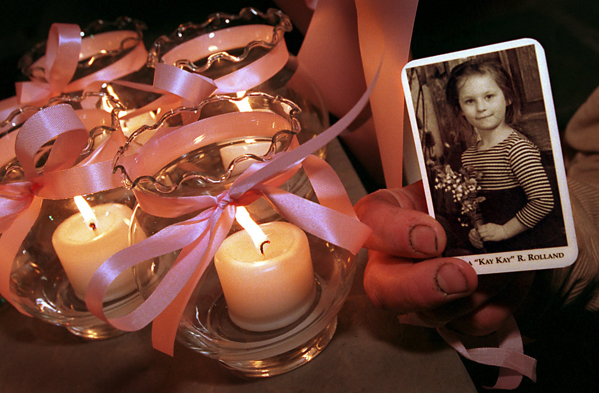 Kayla Rolland's picture is held by Flint resident and family friend Tim Curran after a public memorial service in her honor on Friday March 3, 2000. Six candles were placed outside Brown Funeral Home in Flint for each of Kayla's six years. A first grader at Buell Elementary School in Mt. Morris Township, Kayla was shot and killed at the school by another first grader on Tuesday February 29. (Flint Journal File Photo by Steve Jessmore)