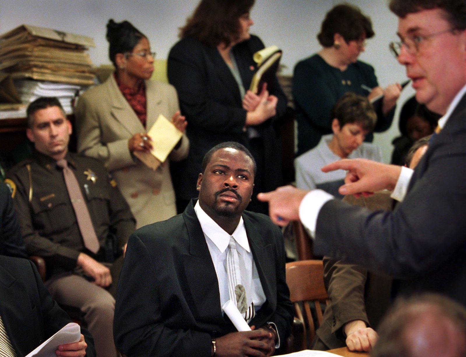 Dedric Owens, seated, listens to Genesee County prosecutor Arthur A. Busch during a neglect hearing in the family division of Genesee County Circuit Court on Tuesday March 21, 2000. Owen's 6-year-old son shot and killed first grade classmate Kayla Rolland at Buell Elementary School on February 29, 2000. (Flint Journal File Photo by Steve Jessmore)