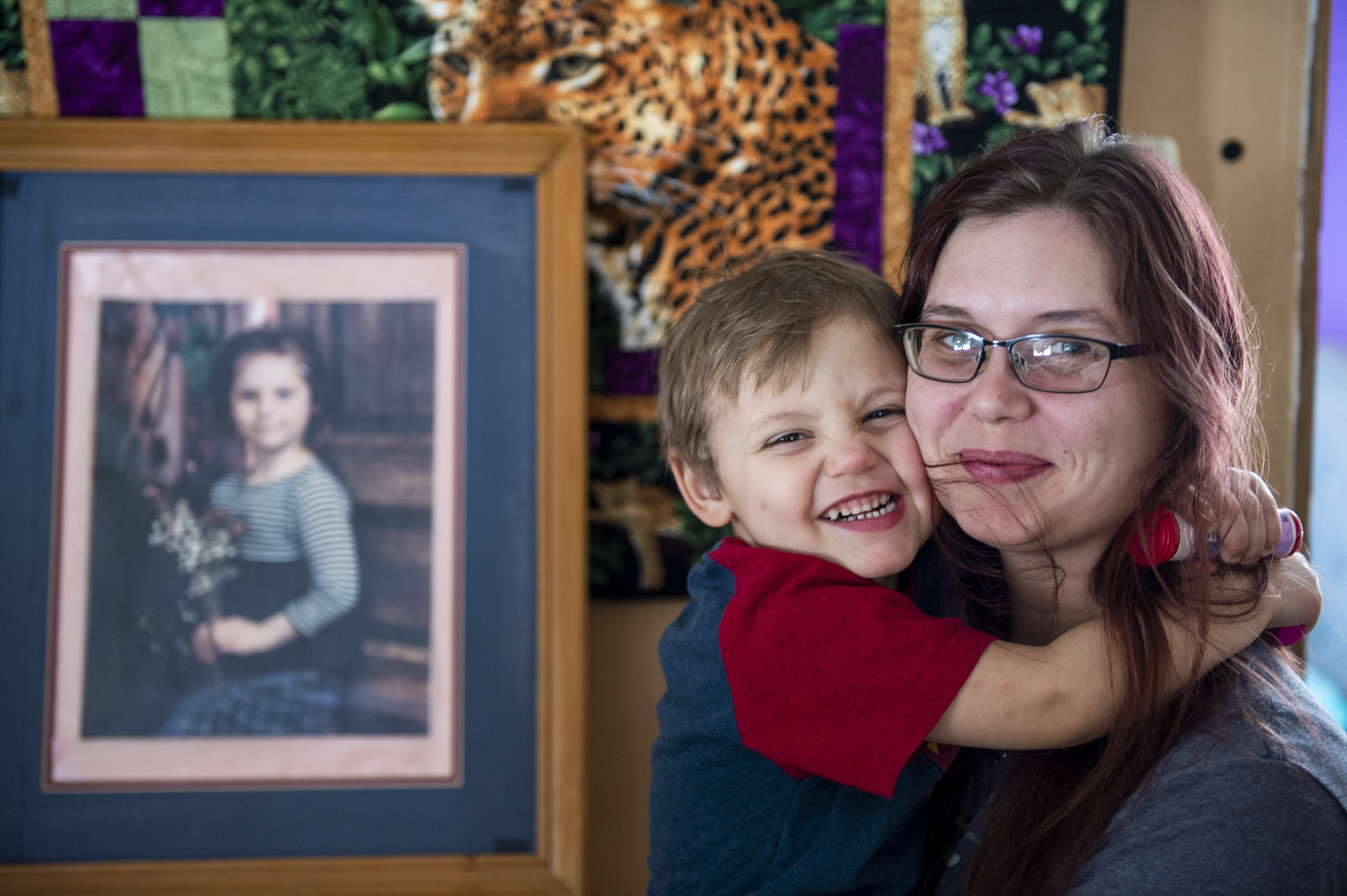 Elizabeth Krasinski and her son Daniel Krasinski Jr., 3, pose for a photograph in Tawas City on Thursday, Feb. 20, 2020. Elizabeth lost her sister, Kayla Rolland (pictured in the frame), 20 years ago in a school shooting when Rolland was only in first grade. In 2000, the story made national news as Rolland is amongst the youngest of school shooting victims.