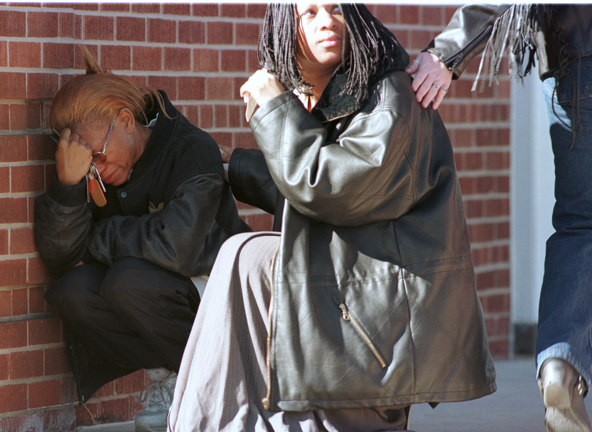 Comforted by Yvonne Owen, right, Gwendolyn Martin, left, is overcome with emotion outside the Brown Funeral Home in Flint, Mich., Friday, Mar. 3, 2000. Owen and Martin were leaving the funeral home after paying respects to Kayla Rolland, a six-year-old who was fatally shot by a six-year-old classmate Tuesday. (Flint Journal File Photo by Al Goldis)