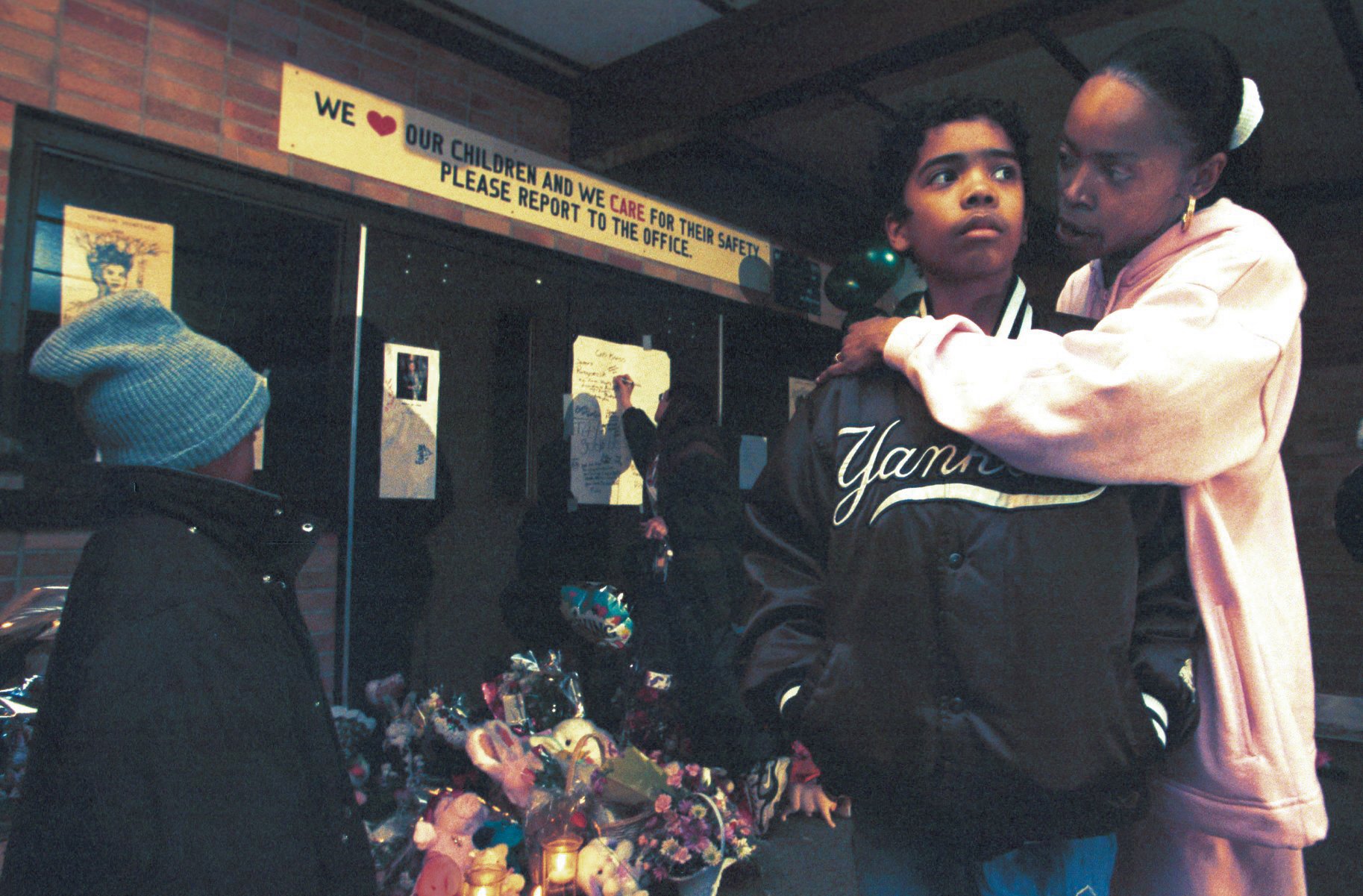 Chevella Groce of Mt. Morris Twp comforts her son DeVonte, 12, at Buell Elementary School Wednesday afternoon, March 1, 2000. She also brought son Kyran, 7, (left), and two other sons (not pictured) Christopher, 6, and Frank III, 8. (Flint Journal File Photo by Jane Hale)